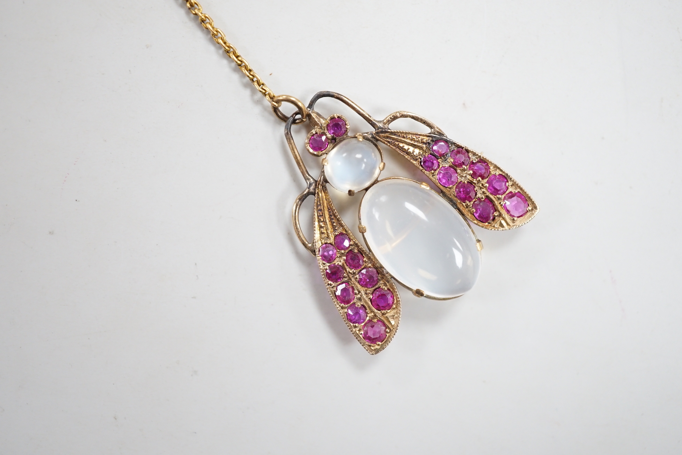 A yellow metal moonstone and ruby cluster set bug brooch, 27mm, gross weight 4.9 grams.